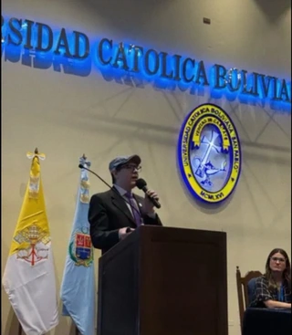 Enrique Revollo hablando desde el atril del auditorio de la Universidad Católica Boliviana.